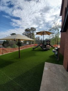 This church playground includes play structures, shade and artificial turf